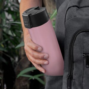 Pesona guardando en su mochila una botella  térmica ALLY de acero inoxidable de color rosa, tapa plástica negra con traba de seguridad y botón de apertura