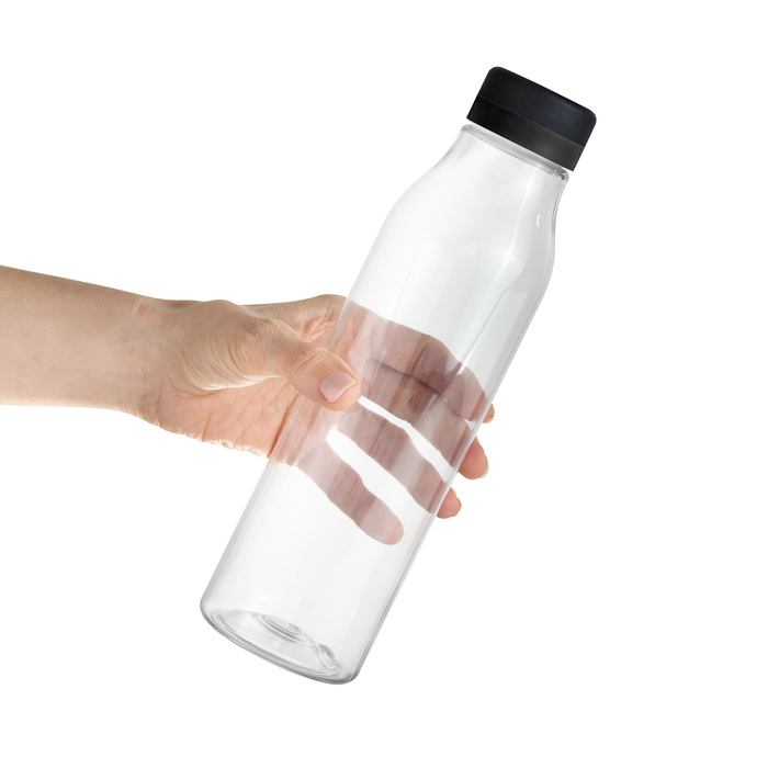 Mano sosteniendo botella de plástico transparente con tapa a rosca color negro mate con anillo de silicona color negro.